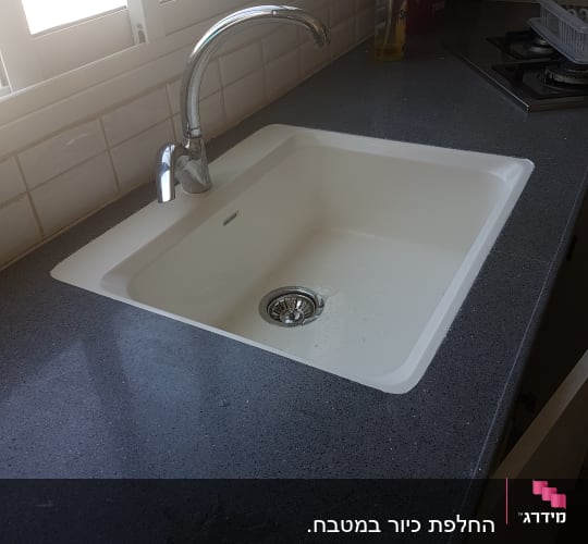 שיש כהה עם כיור לבן וברז מתכת מבריק
